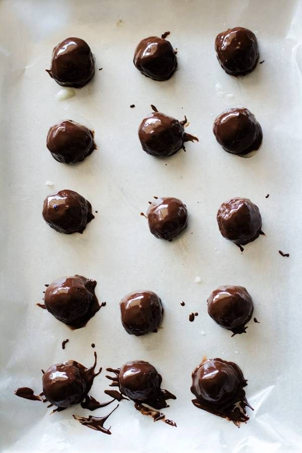 Dark chocolate coconut bites on parchment paper.
