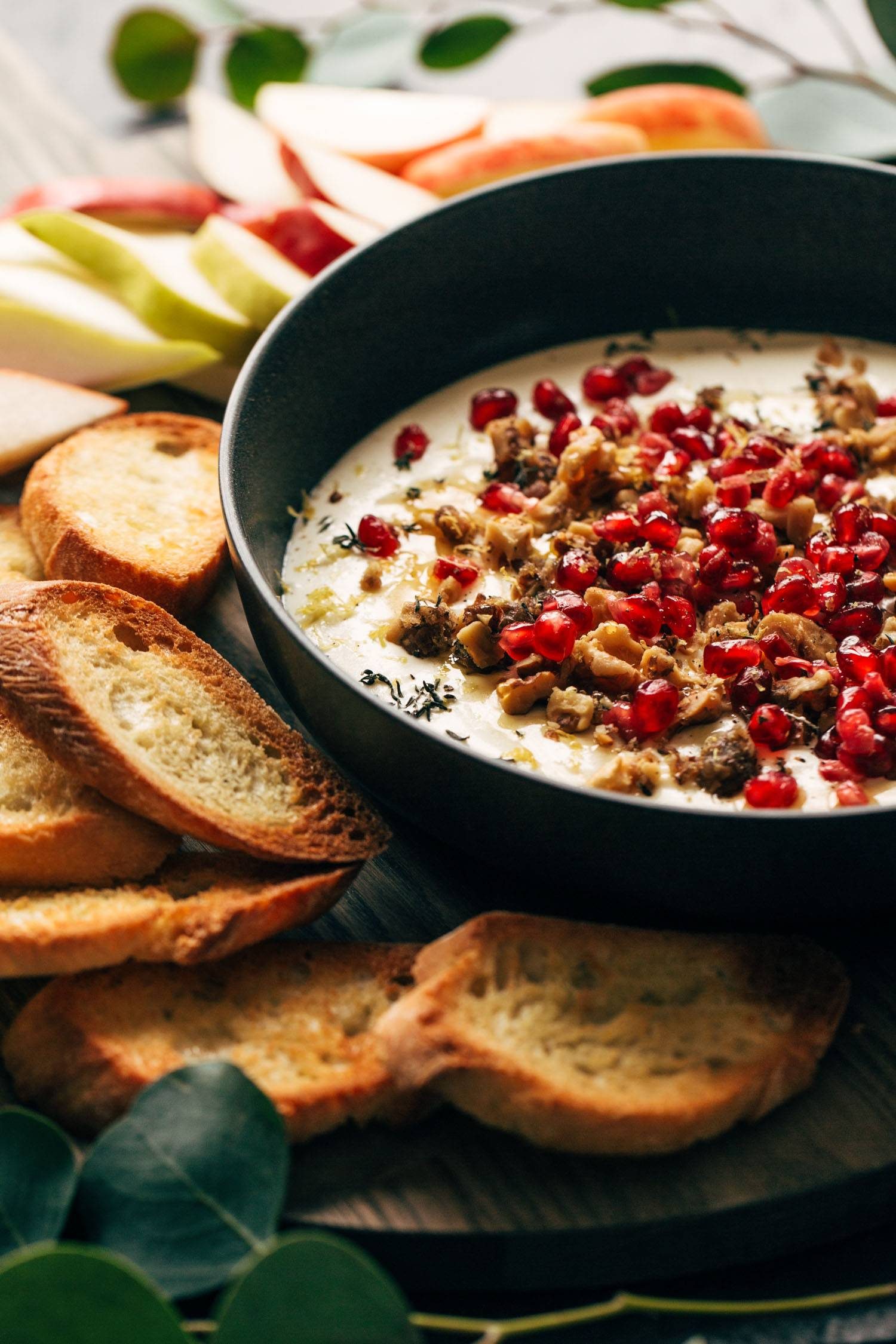 Whipped feta in a bowl with crackers and fruit on the side.