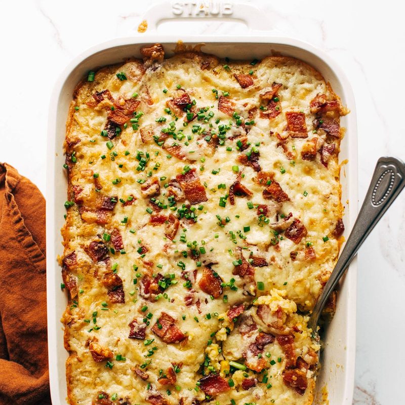 Corn casserole in a casserole dish with a serving spoon.