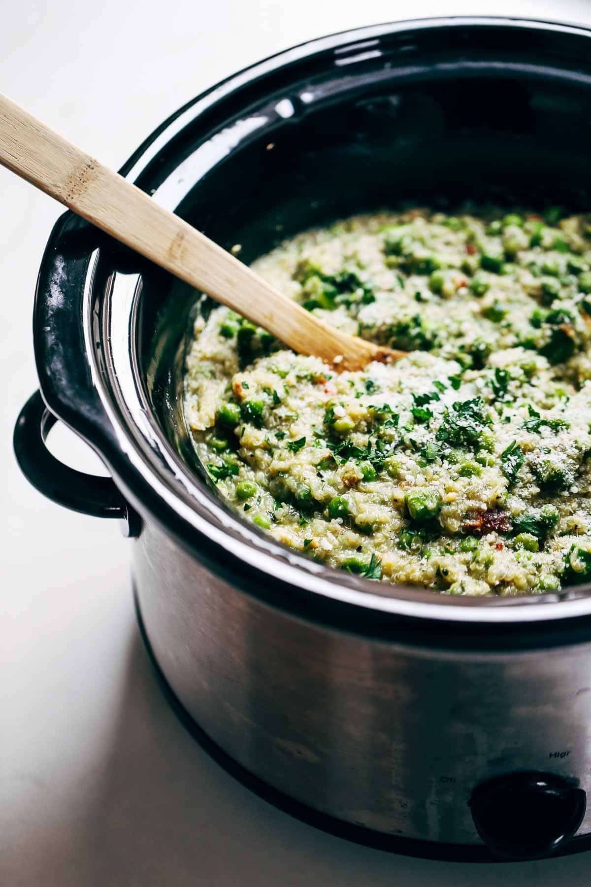 Crockpot Quinoa Chicken Primavera with a wooden spoon.