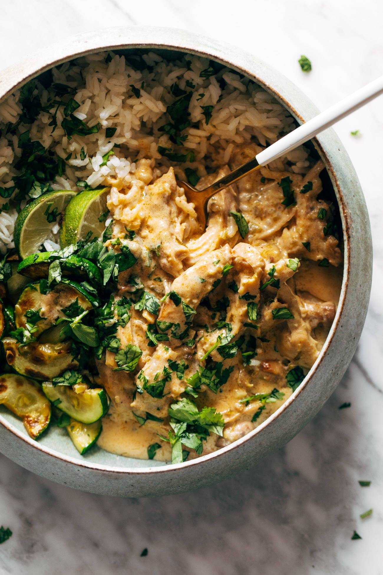 Creamy lemongrass chicken in a bowl with rice and zucchini.