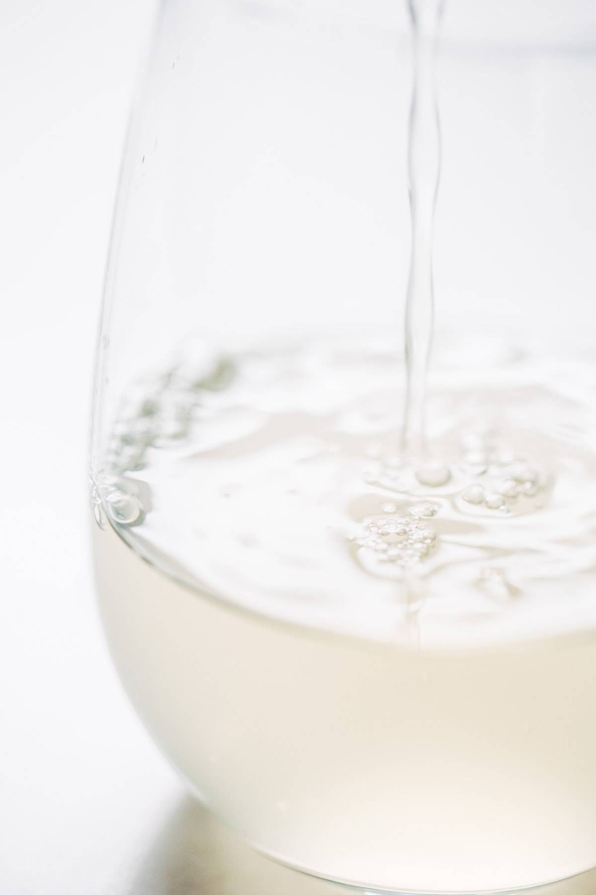 Clear liquid pouring into a glass.