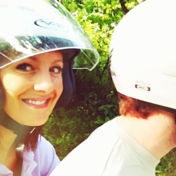 Man and woman wearing helmets on a motor bike.