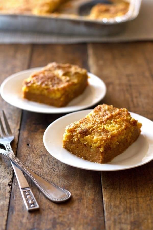 Two pumpkin bars on white plates.
