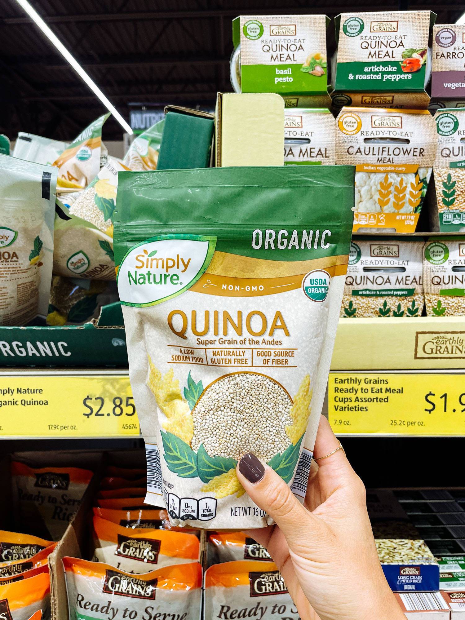 White hand holding bag of quinoa from ALDI.