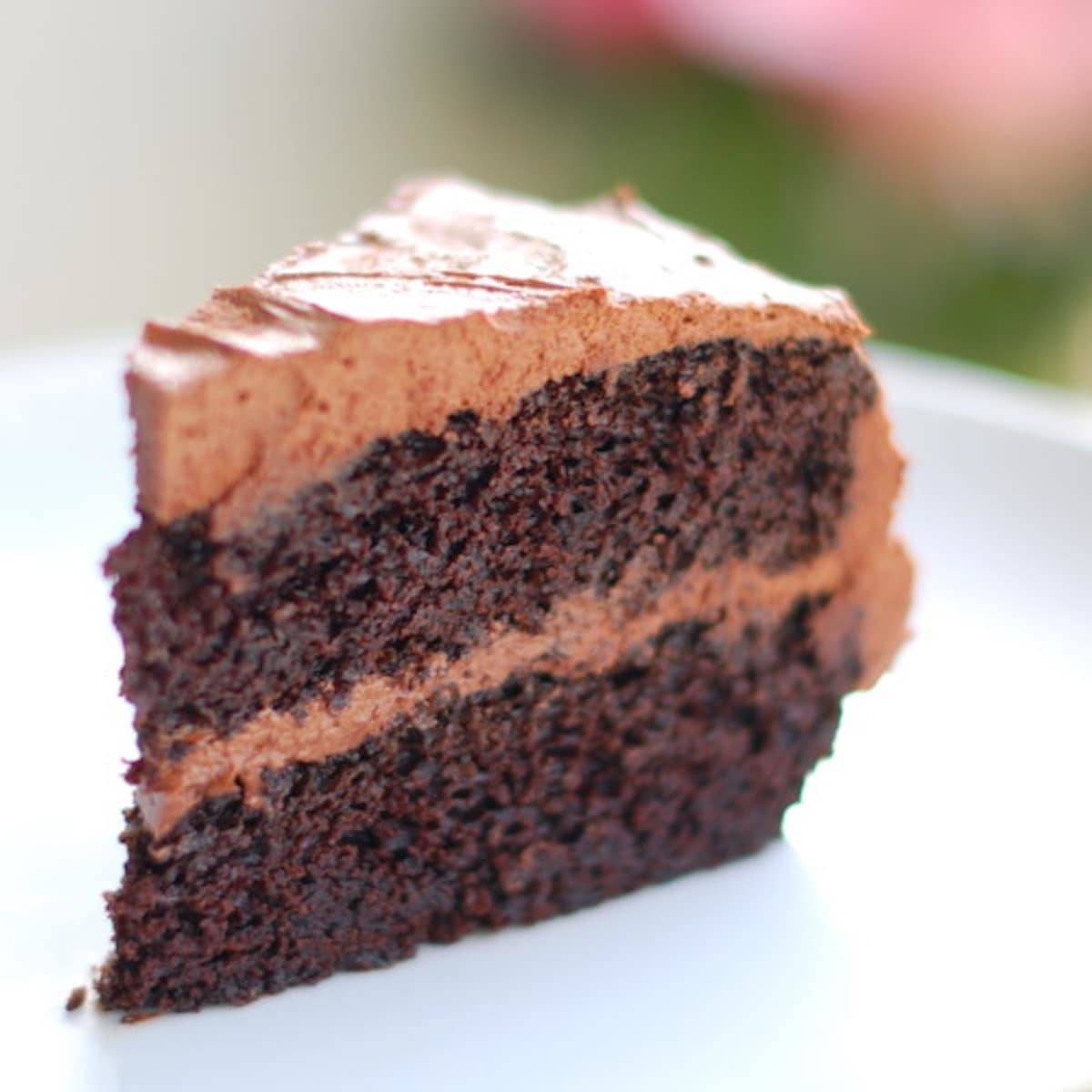 Slice of double chocolate cake with buttercream frosting.