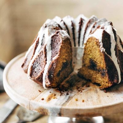 Pumpkin Bundt Cake on cake stand with glaze.