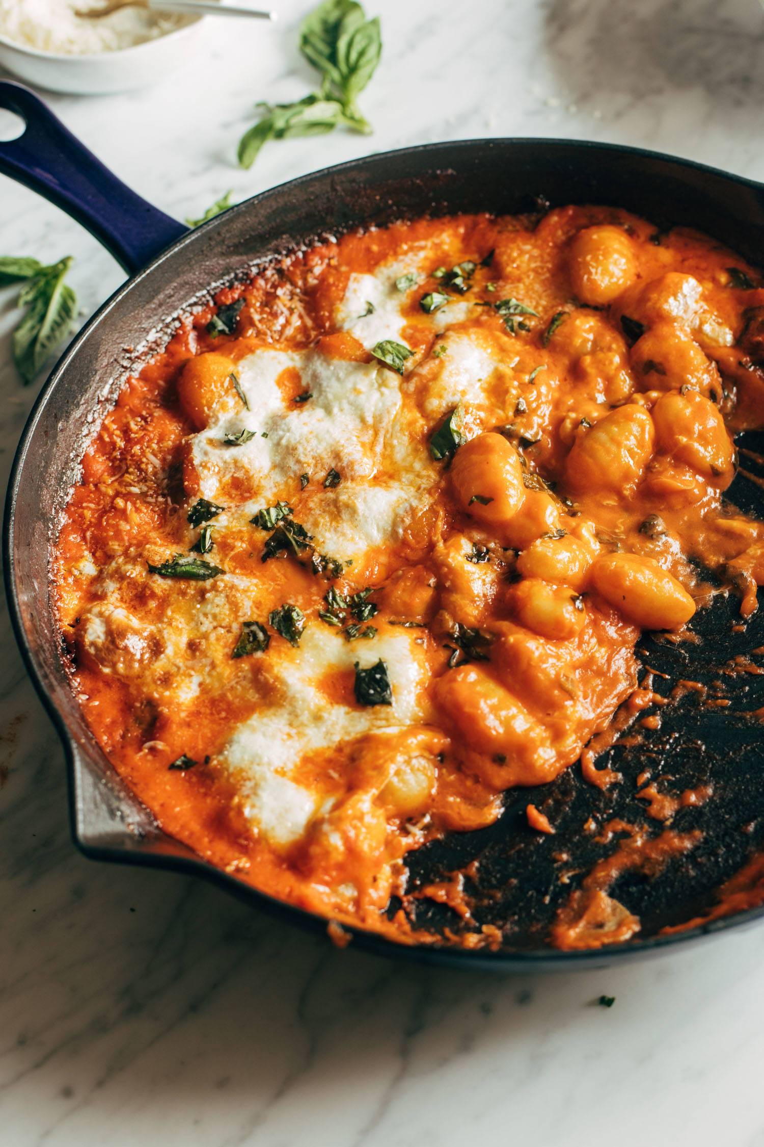 Three cheese baked gnocchi in a cast iron pan.